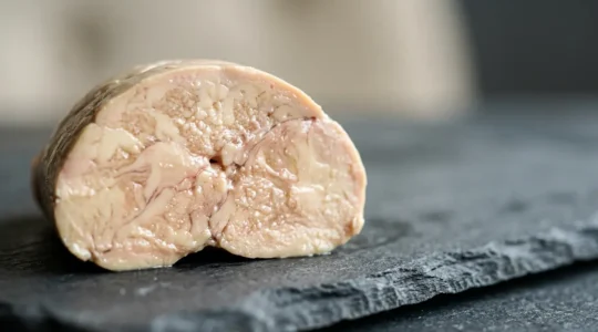 Cross-section view of premium foie gras displaying silky marbled texture contrasted with ordinary liver