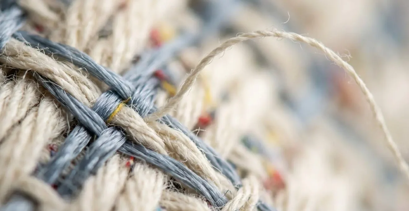 Macro close-up of fabric fibers revealing the hidden complexity behind clothing labels